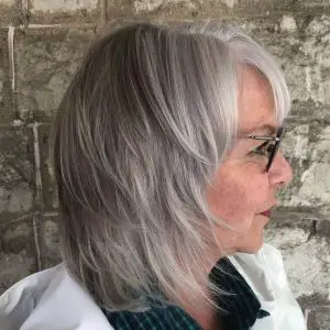 Layered bob hairstyle for women over 50 with glasses